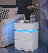 avec bande lumineuse LED bleue. Dispose de trois tiroirs et est présentée dans un décor de chambre à coucher surmonté d'un vase de fleurs.