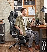 Chaise de bureau ergonomique noire avec dossier haut, appui-tête réglable et accoudoirs rembourrés présentée dans un cadre de bureau à domicile avec bureau en bois et fond de mur de briques