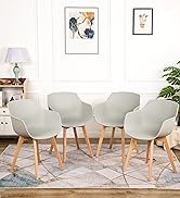 Ensemble de quatre chaises de salle à manger modernes gris clair avec sièges incurvés et pieds en bois, disposées autour d'un tapis à motifs dans une pièce lumineuse