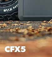 Vue rapprochée d'une bande de roulement de pneu noire et d'une partie d'un objet gris sur un sol recouvert de feuilles. Texte « CFX5 » visible en blanc en bas