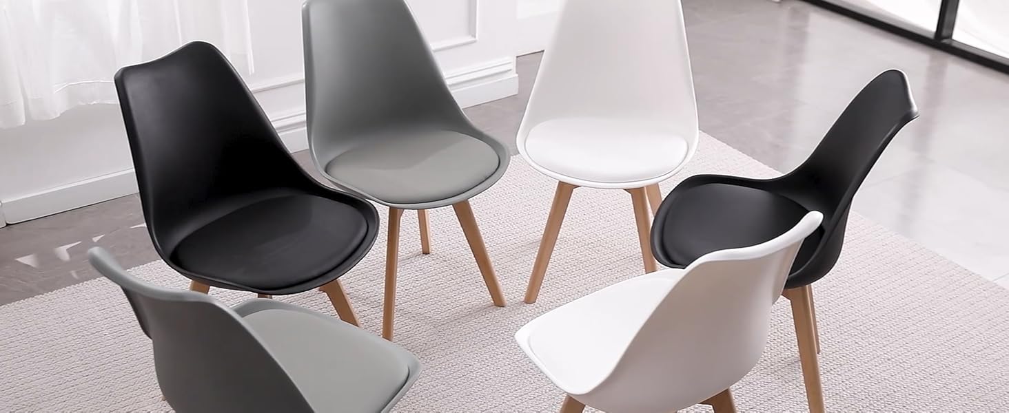 Ensemble de chaises de salle à manger modernes aux couleurs noir et blanc, entourant une petite table ronde blanche dans une pièce lumineuse.
