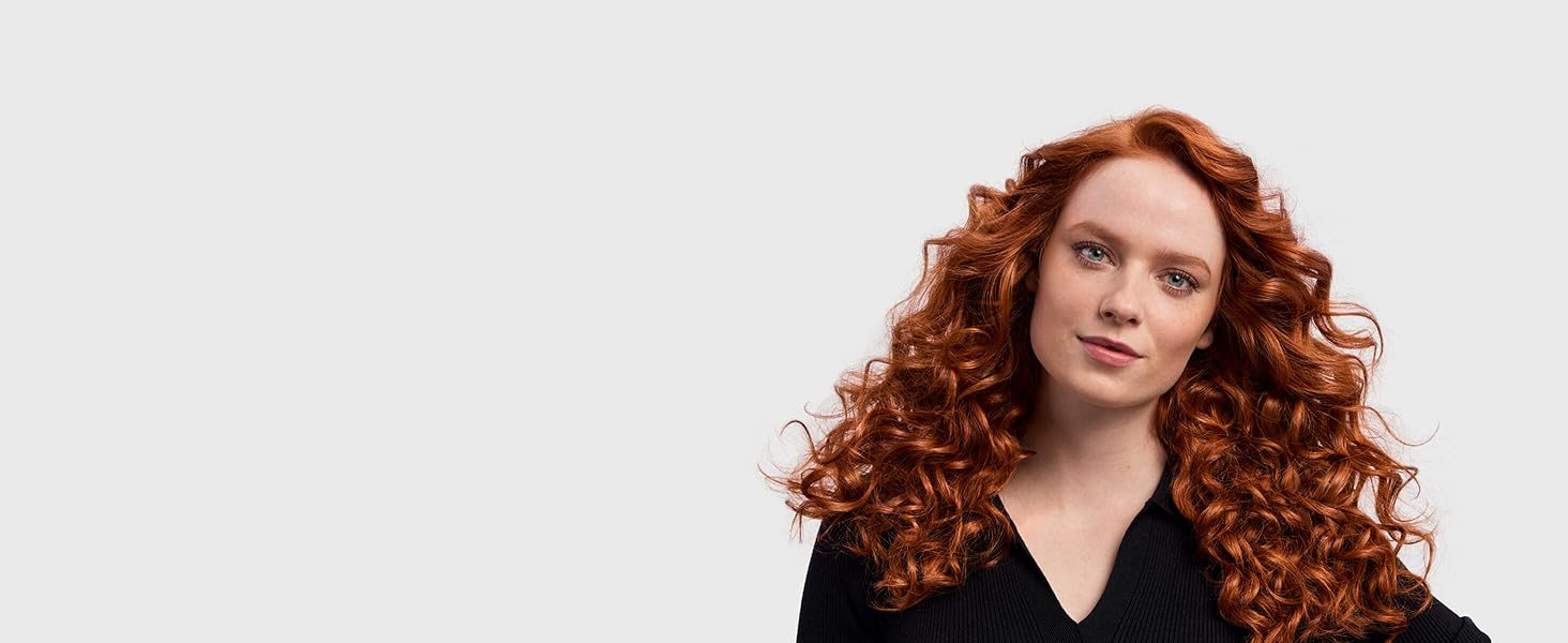 Un mannequin aux cheveux longs et roux avec des boucles style années 1980.