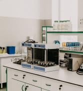 Environnement de laboratoire avec équipement scientifique, y compris des tubes à essai et des instruments d'analyse sur une surface de comptoir blanche.