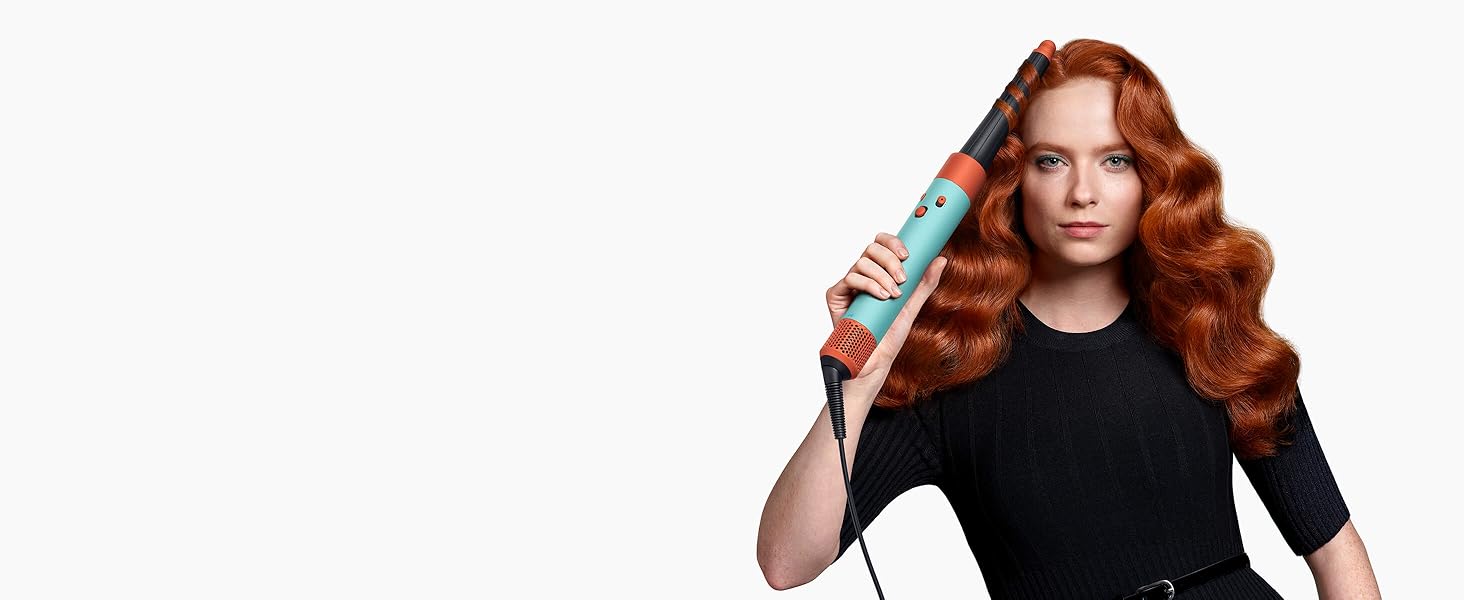 Un mannequin aux cheveux roux utilise le rouleau conique Airwrap pour onduler ses cheveux.