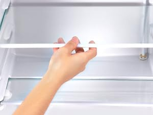 une main qui ouvre la porte d'un réfrigérateur.